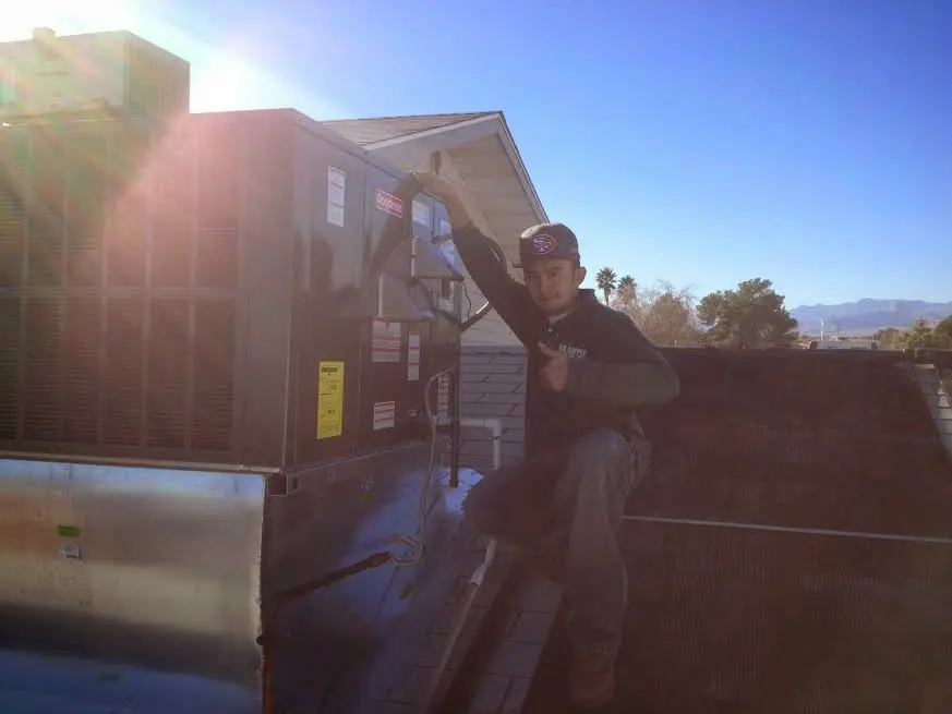 HVAC technician performing AC Tune-Up on a rooftop unit in Merchantville